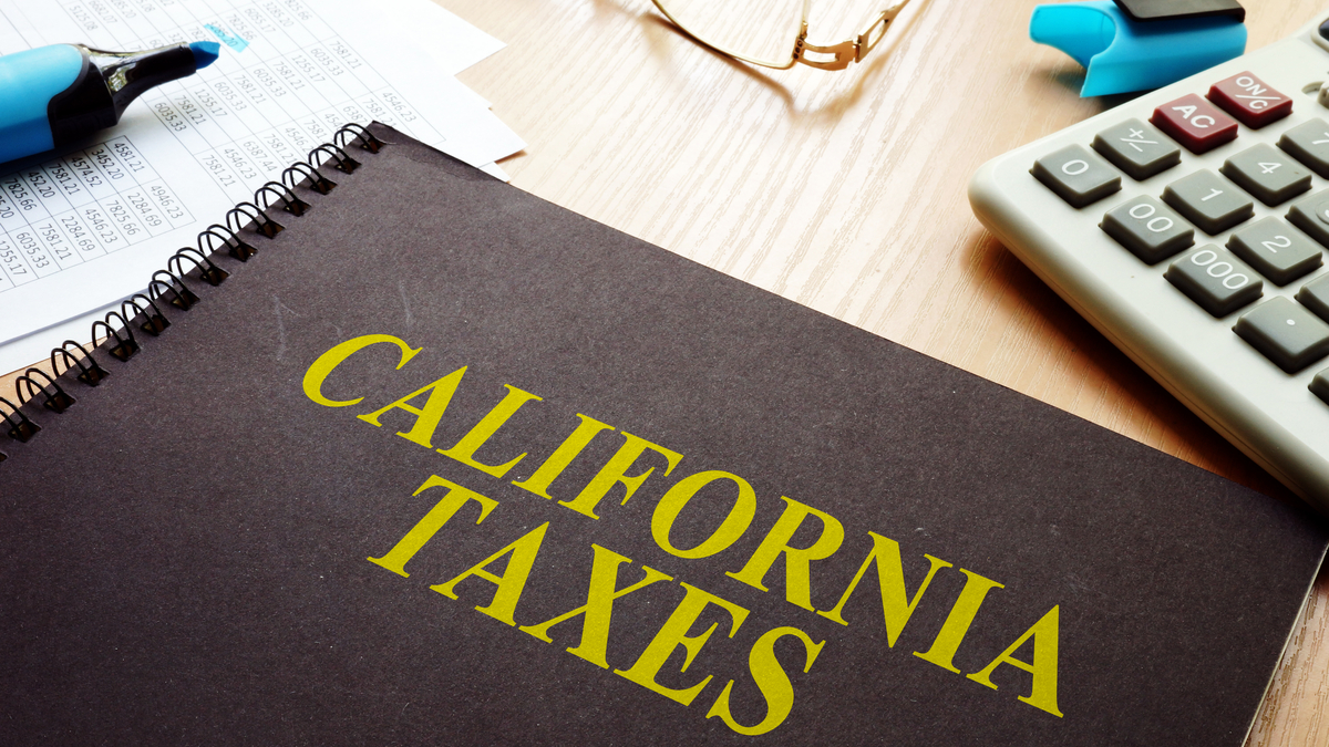 Picture of a ledger on a desk. The ledger is titled "California Taxes."