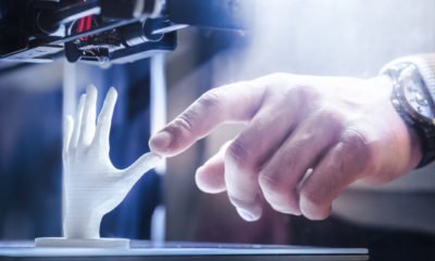 Photo of a 3D printer creating a plastic hand