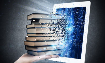 Photo Illustration of a pile of books being absorbed by a laptop