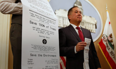 Photo of Assemblyman Phil Ting of San Francisco with a long paper receipt