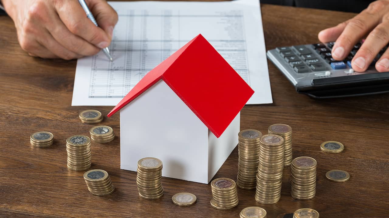 Photo of a house and coins