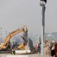 Photo of crews working to demolish border wall prototypes