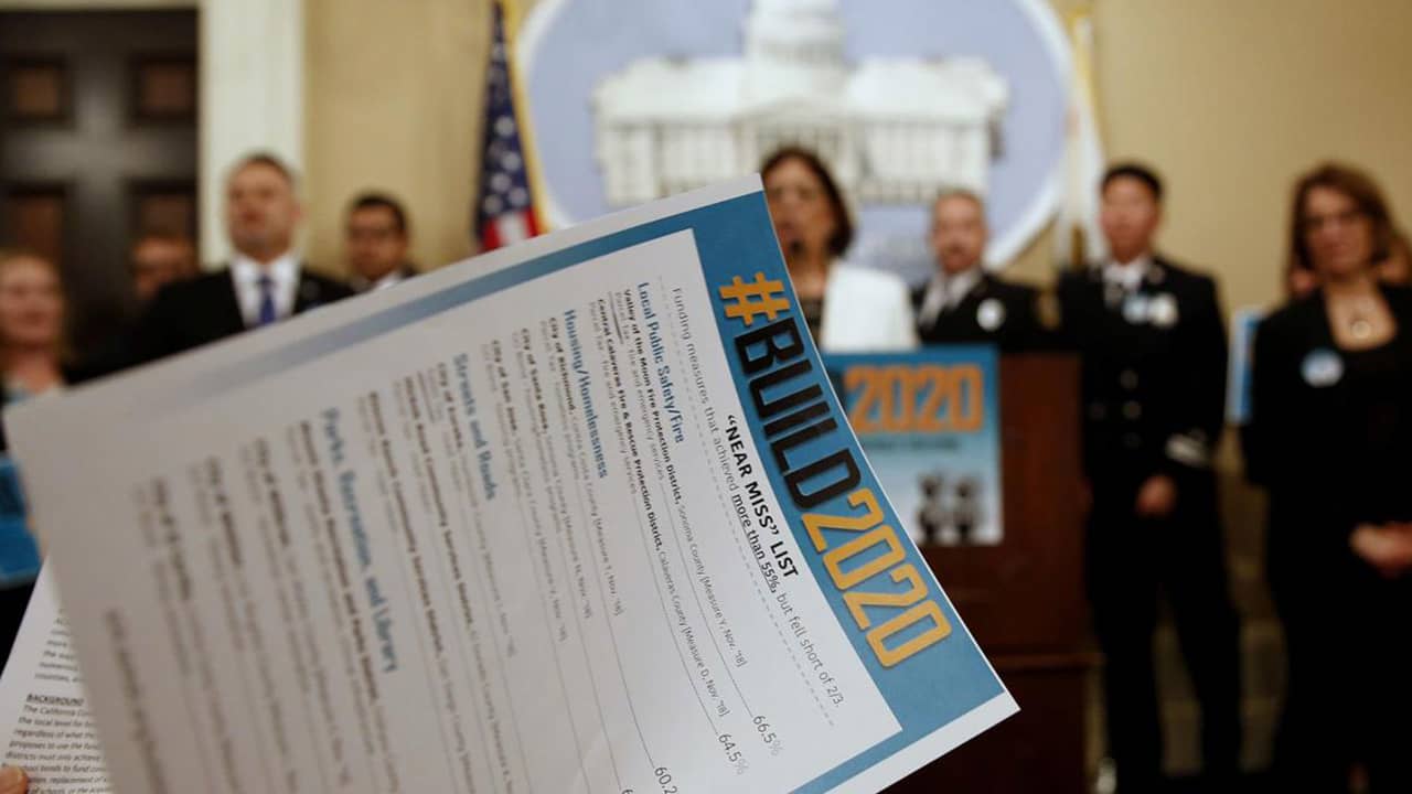Photo of a reporter looking over a list of local government projects