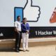 Photo of visitors taking pictures in front of the Facebook logo