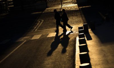 Photo of elderly couple walking across a street