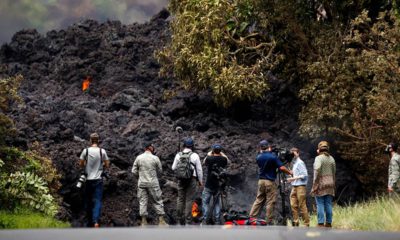 Photo of members of the media recording the wall of lava in Pahoa, HI