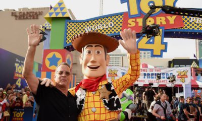 Photo of Tom Hanks posing with his character, Woody