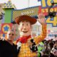 Photo of Tom Hanks posing with his character, Woody