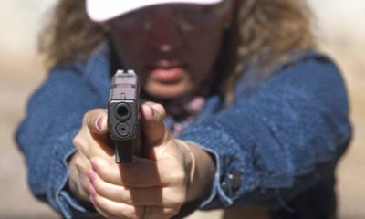 Photo of school secretary aiming a pistol at a shooting range