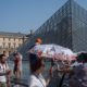 Photo of people cooling next tot he fountain at Louvre Museum in Paris
