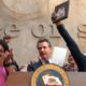 Photo of Gov. Gavin Newsom surrounded by Assemblywoman Shirley Weber and members of the Clark family after the signing of AB 392 lFam
