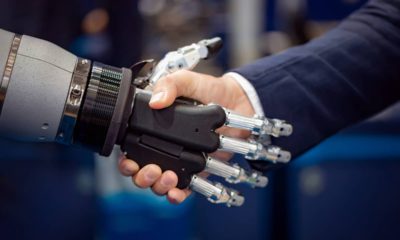 Photo of a robot shaking hands with a businessman