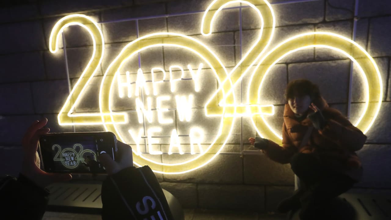 Photo of a woman posing next to a 2020 sign for a photo