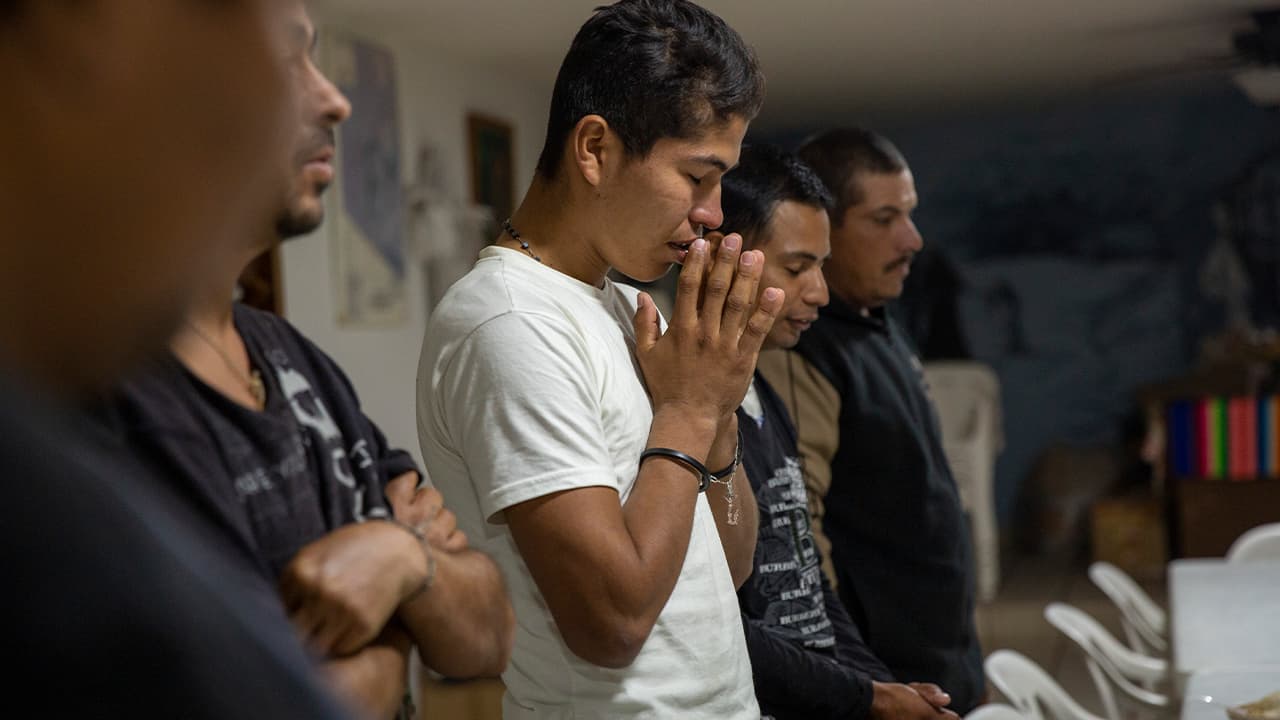 Photo of Honduran migrants praying before dinner