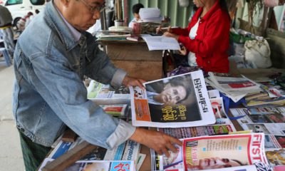 Photo of a man looking through newspapers