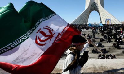 Photo of a boy carrying an Iranian flag