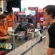 Photo of customer and grocery store cashier separated by a sneeze guard