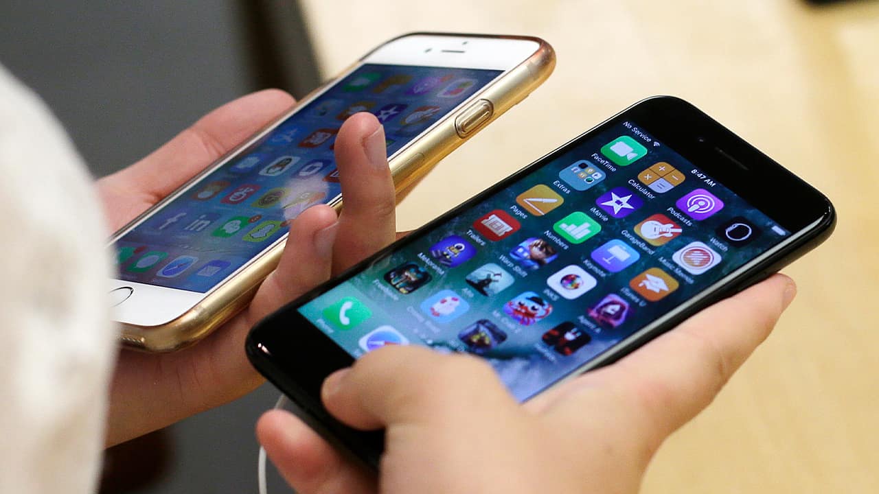 Photo of a customer comparing two iPhones