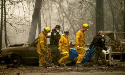 Photo of firefighters and deputies carrying a body of a Camp Fire victim