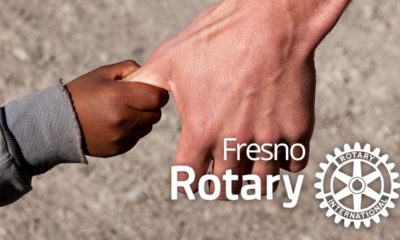 Composite of a man grabbing a child's hand with the Fresno Rotary logo po