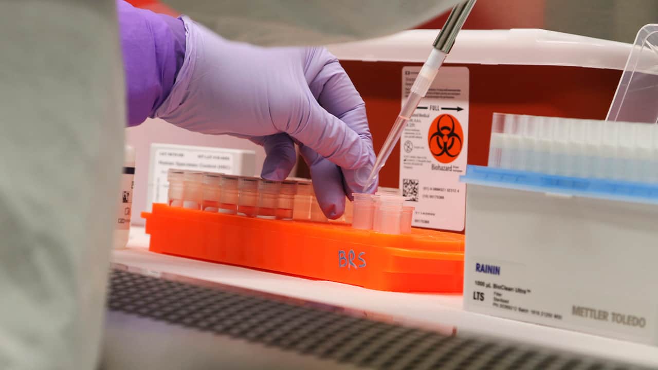 Photo of a microbiologist testing a sample of coronavirus