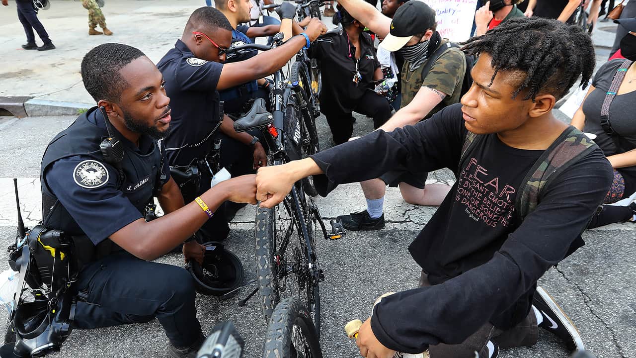 Photo of a police officer fist bumping a protester in Atlanta