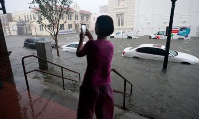 Photo of a woman taking photos of the flooding